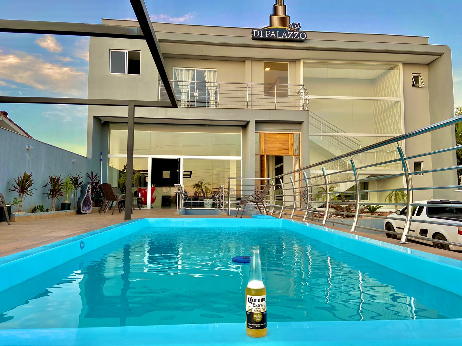 Piscina ampla em frente a hotel com deck e área de convivência